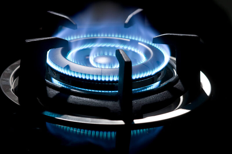 A gas burner running a clean blue flame, the signature of complete propane combustion.