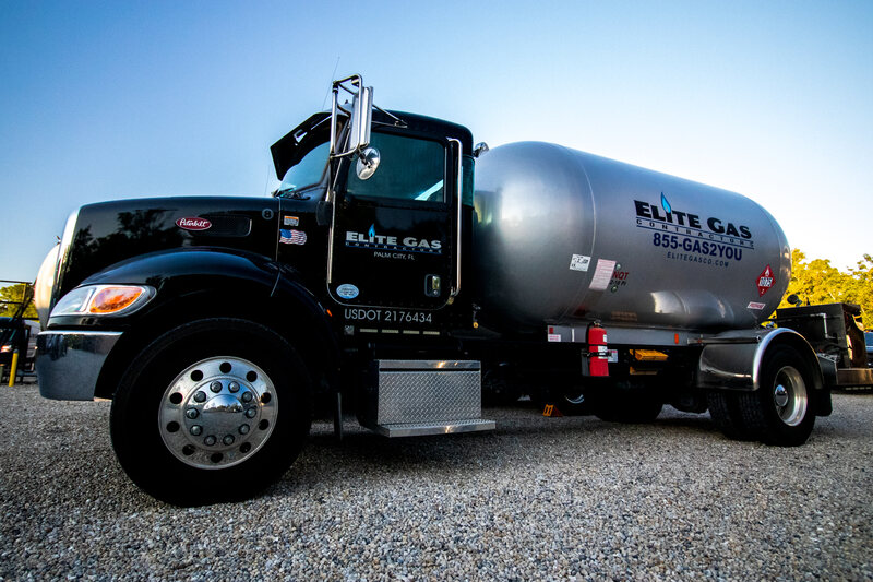 An Elite Gas propane delivery tanker, lettered 855-GAS2YOU, parked under a clear Florida sky.
