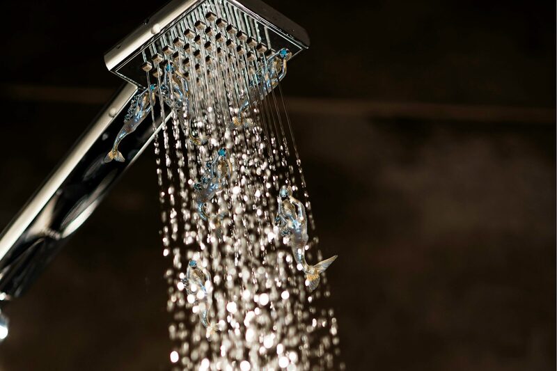 A chrome shower head running a full stream of hot water.