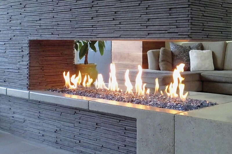 A long linear gas fire feature built into an outdoor patio wall.