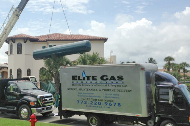 An Elite Gas box truck delivering a propane tank to a residential property in Southeast Florida.